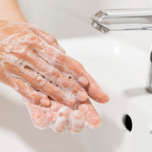 Focus sur les mains d'une personne pratiquant un lavage des mains à l'eau et au savon.