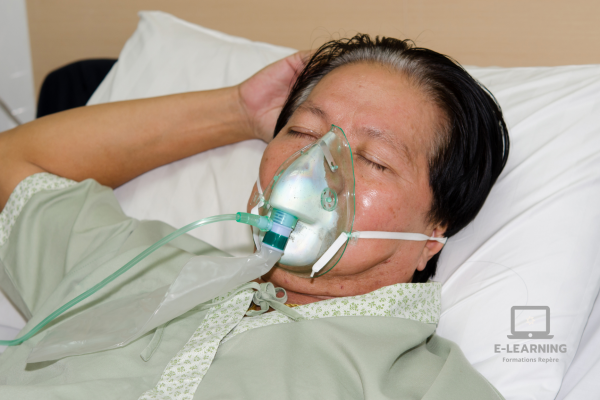 Dame âgée recevant un soin par inhalateur.